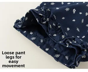 Close-up of navy floral cotton trousers featuring ruffled hems and loose-fit design
