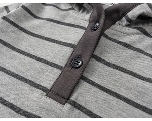 Macro detail of grey striped knit fabric and buttons on the kids hooded shirt