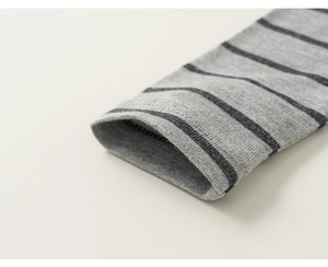 Detailed macro view of the double-needle stitching on gray striped cotton sleeve cuffs