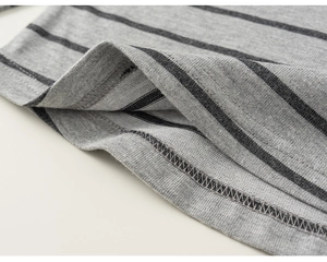 Detail of grey striped knit fabric showing fine double-needle stitching and soft cotton texture