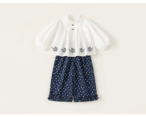 Detailed embroidery on white cotton top paired with floral print wide-leg trousers