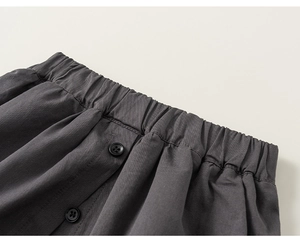 Detailed close-up of kids' trousers with elastic waistband and decorative black buttons