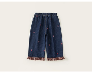 Détail du jean bleu foncé pour fille avec broderie coeur et ourlet à volants en dentelle