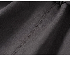 Macro shot of dark grey twill fabric showing detailed double-needle stitching and texture