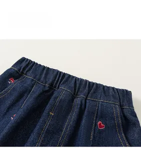 Détail de la taille élastique sur jean enfant avec broderie de petits cœurs rouges