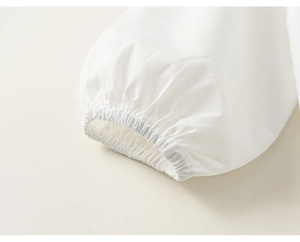 Detailed macro view of elasticated cuffs on a white cotton blouse for girls