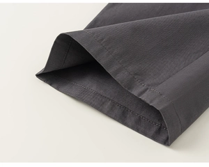 Detailed close-up of double-stitched seams on dark gray cotton fabric for quality assurance