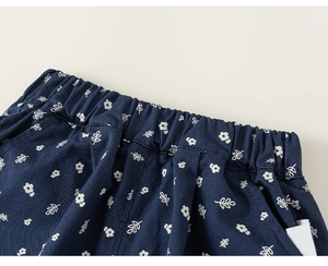 Detail of navy blue floral trousers with elastic waist and delicate leaf patterns