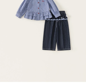 Detail of girls' blue plaid shirt with ruffle hem and wide-leg denim jeans two-piece set