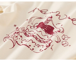 Detailed close-up of ribbed cotton fabric with red cake print on beige girl's t-shirt