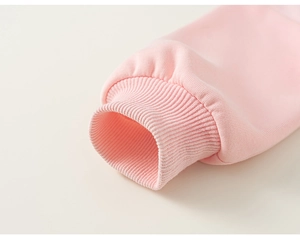 Detail van de geribbelde manchetten op een roze kindersweatshirt met zachte breisels