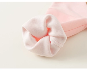Detailopname van roze gebreide stof met zachte textuur en nette stikseldetails