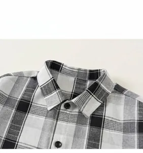 Detail of boys' plaid shirt featuring classic black and white check pattern and buttons