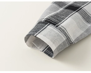 Detail of classic black and white plaid shirt cuff with high-quality cotton fabric stitching