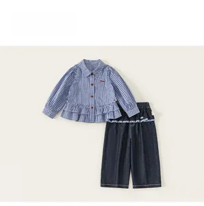 Detail of baby girl stripe shirt with ruffle hem and red buttons on soft fabric