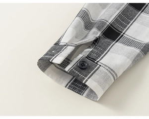 Detailed macro view of black and white plaid shirt cuff with a single black button