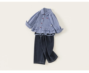 Detail of girls' blue striped shirt with red buttons and matching dark denim trousers