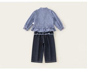 Rear view of girls casual outfit with blue plaid ruffle hem top and denim pants