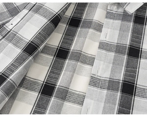Macro shot of black and white plaid shirt fabric texture and neat buttonhole detail