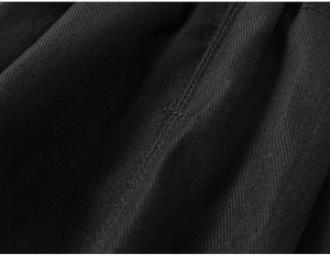Detail of reinforced bar-tack stitching on black twill boys' cargo pants fabric