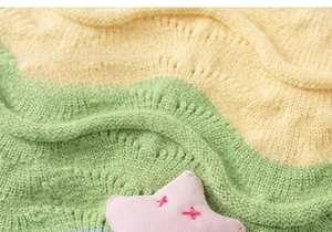 Close-up of yellow and green knitted fabric with pink 3D star charm detail for kids