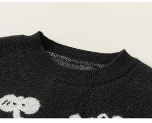 Detail of ribbed crew neck on black knitted sweater featuring white Snoopy cartoon pattern