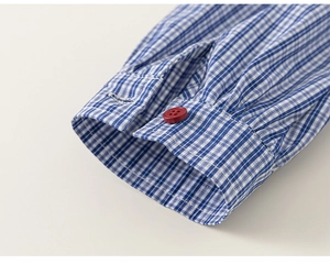 Detailed macro view of the blue and white checkered cuff featuring a red bead button
