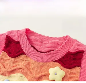 Close-up of colorful wavy knit vest with round lace collar and 3D yellow flower detail