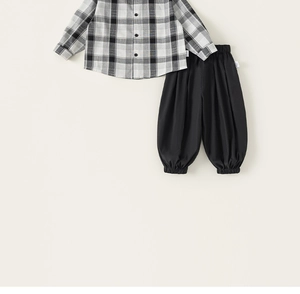 Flat lay detail of boys black and white plaid shirt and casual elastic waist trousers set