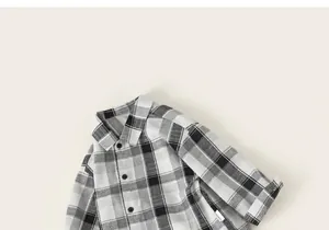 Detailed view of kids long-sleeve plaid shirt featuring black and white contrast check pattern