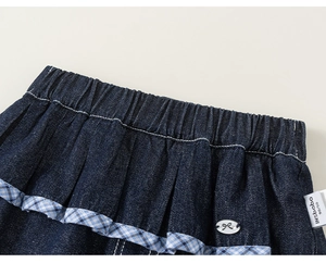 Detail of girls denim outfit featuring elastic waistband and plaid ruffle trim details