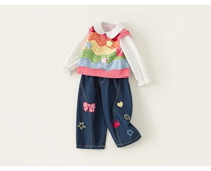 Detail view of girls' white shirt, rainbow knit vest, and jeans with colorful patches