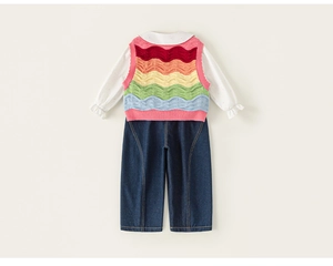 Detail of colorful striped knitted vest with white shirt and blue denim jeans for girls