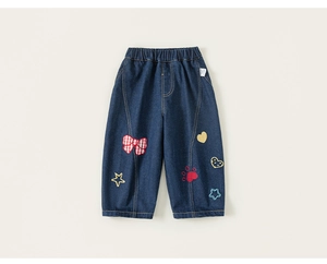 Detail of girls denim jeans featuring colorful star and heart embroidery with elastic waist