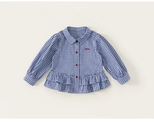 Detail of girls plaid shirt featuring Peter Pan collar, red buttons and ruffled hemline