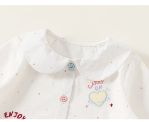 Close-up of Peter Pan collar and colorful polka dot fabric with heart embroidery