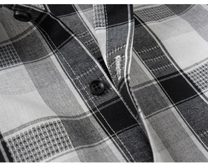 Close-up of black and white plaid shirt fabric showing buttons and fine sewing detail