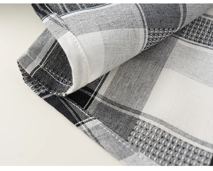 Close-up of black and white plaid cotton fabric with high-quality stitching on the hem