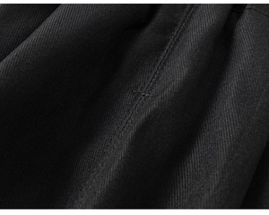 Detailed macro view of black twill fabric texture with reinforced stitching on boy's pants