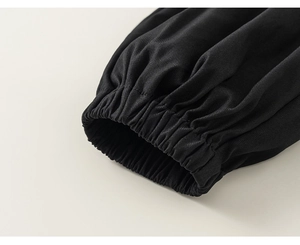 Detail of black twill fabric kids' long sleeve with elastic cuffs and textured finish