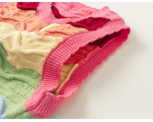 Close-up of vibrant wave pattern cable knit on a colorful toddler knitted sweater vest