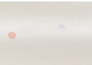 Nahaufnahme von weißem Baumwollstoff mit rosa und lila Punkten für Kinderbekleidung