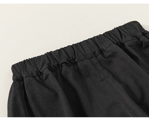 Detail of boys' black casual trousers featuring a comfortable wide elastic waistband