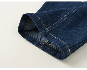 Detail of dark blue denim hem with contrast yellow double stitching and high quality texture