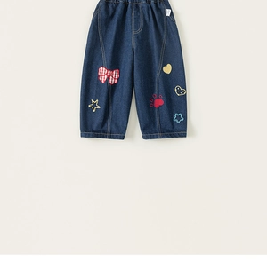 Dettaglio dei jeans larghi per bambini con ricami a fumetti e vita elasticizzata