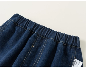 Makro-Detail der Kinder-Jeans mit elastischem Bund und gelben Kontrastnähten
