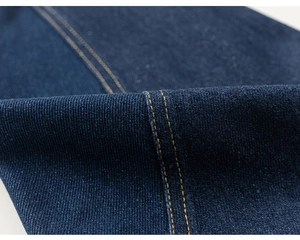 Dettaglio del denim blu scuro con doppie cuciture gialle e trama in tessuto twill
