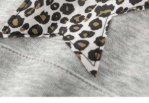 Detail der Stern-Applikation im Leopardenmuster auf grauem meliertem Strickpullover