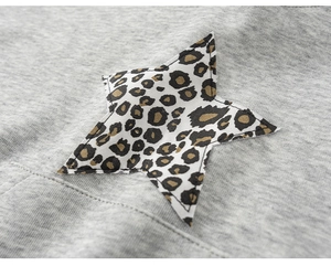 Detail von grauem Strickstoff mit Sternen-Applikation in Leopardenmuster-Optik