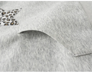 Detail des grauen Strick-Hoodies mit Stoffstruktur und Tasche mit Stern-Leopardmuster